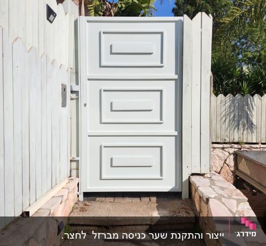 שער מתכת לבן עם עיטורים גיאומטריים
